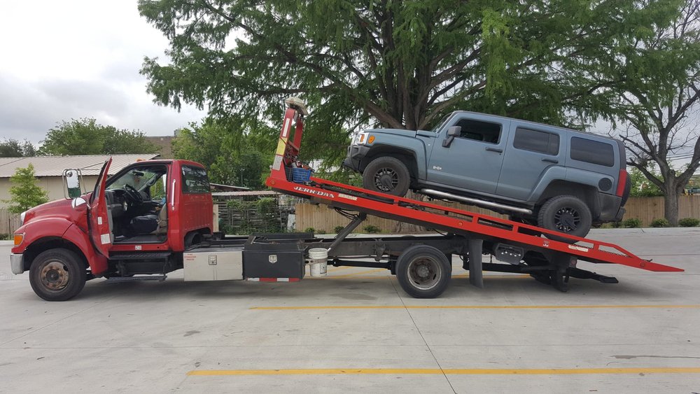 Gray SUV being loaded onto a red flatbed - AA Affordable Towing