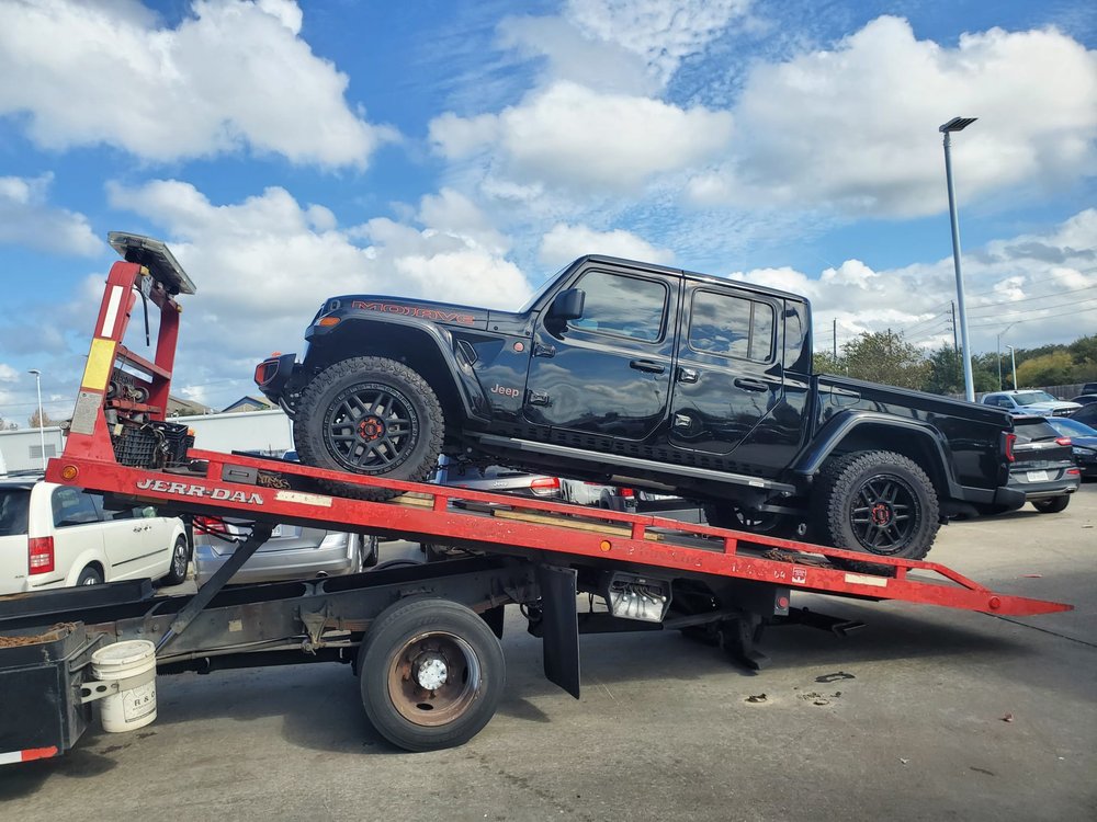 Black Jeep pickup loaded on a red flatbed - AA Affordable Towing